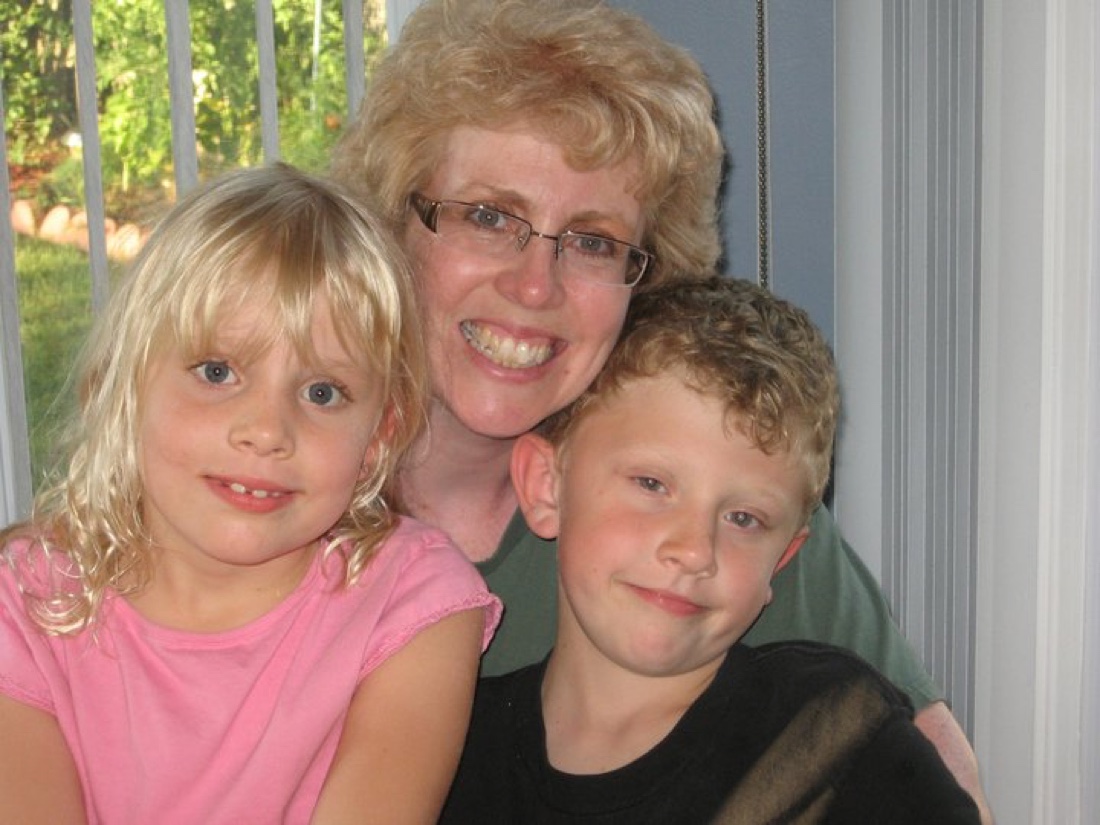 Belynda with two young children, all three smiling closely together