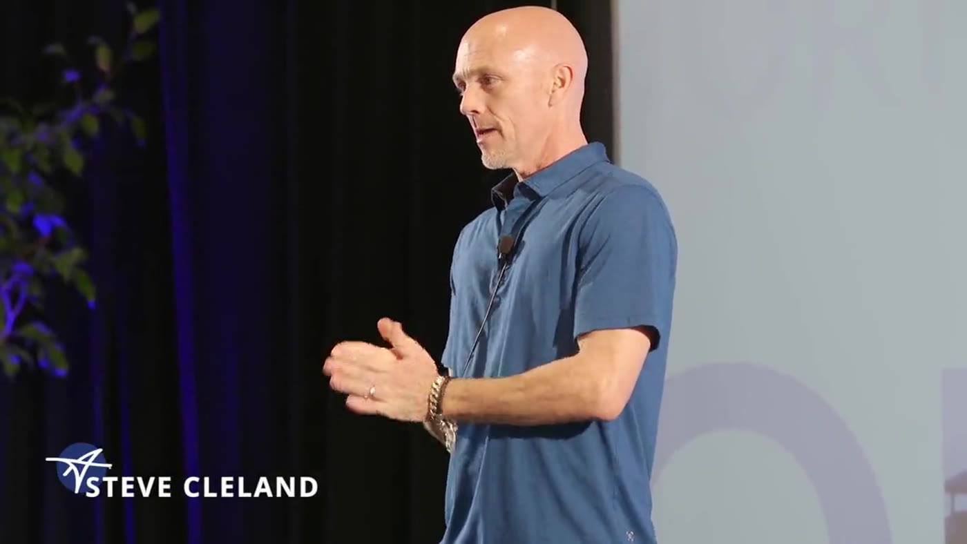 Steve Cleland speaking on stage at a conference